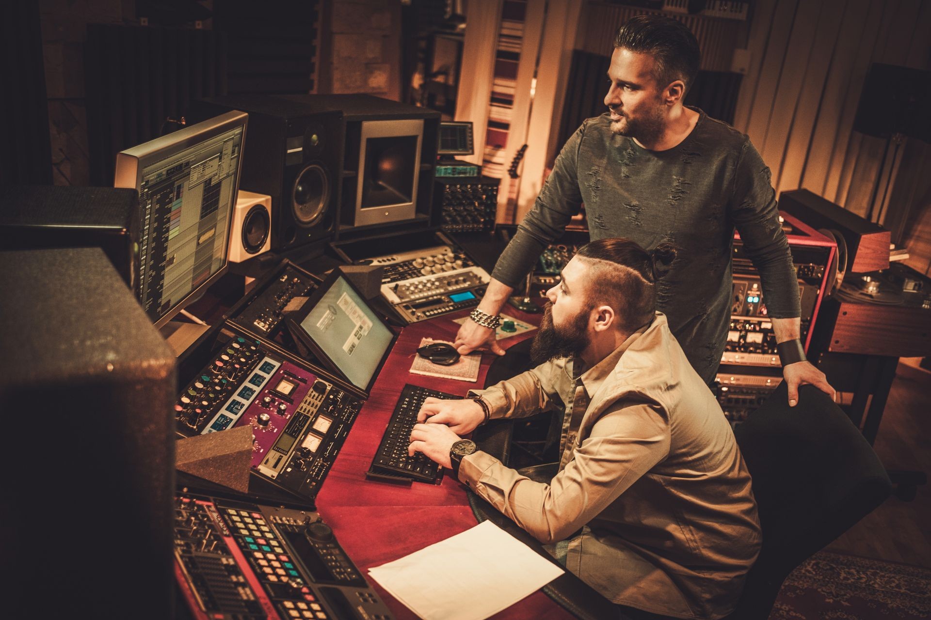 Sound engineer and musicians working in boutique recording studio.